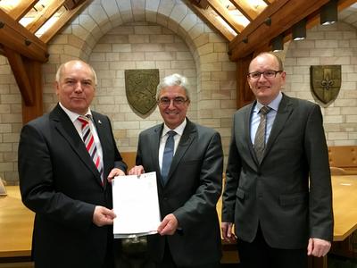 Bild vergr&ouml;&szlig;ern: Oberbürgermeister Hans Georg Löffler und »Kämmerer« Stefan Ulrich freuen sich über den Bewilligungsbescheid aus den Händen des rheinland-pfälzischen Innenministers Roger Lewentz (Mitte)