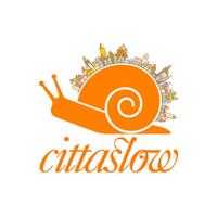 Bild vergr&ouml;&szlig;ern: Es ist eine orangene Schnecke zu sehen, auf deren Rücken die bunte Skyline einer Stadt zu sehen ist. Darunter steht der schnörkelige Schriftzug "Cittaslow".