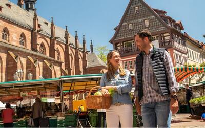 Bild vergr&ouml;&szlig;ern: Ein paar schlendert über den Neustadter Wochenmarkt.