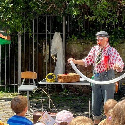 Clown Giovanni hält einen Ballon in der Hand, den er zu einem Hund geformt hat.