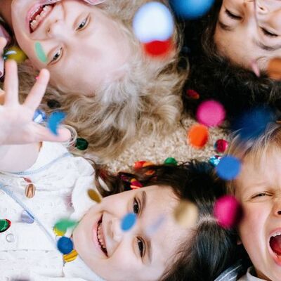 Bild vergr&ouml;&szlig;ern: Kinder werfen buntes Konfetti in die Luft