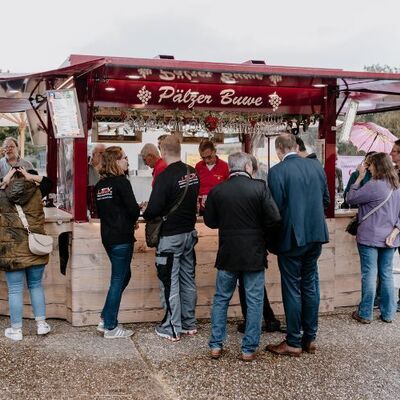 Bild vergr&ouml;&szlig;ern: Besucher stehen am Getränkestand beim feierlichen Baubeginn der Landesgartenschau 2027 Neustadt an der Weinstraße