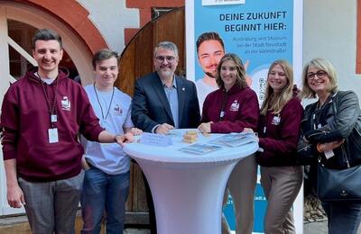 Bild vergr&ouml;&szlig;ern: Zu sehen sind Mitarbeiterinnen und Mitarbeiter der Stadtverwaltung Neustadt an der Weinstraße und der Wirtschaftsentwicklungsgesellschaft an einem Stehtisch. In der Mitte steht Oberbürgermeister Marc Weigel.