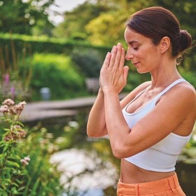 Bild vergr&ouml;&szlig;ern: Eine Frau macht Yoga im Garten
