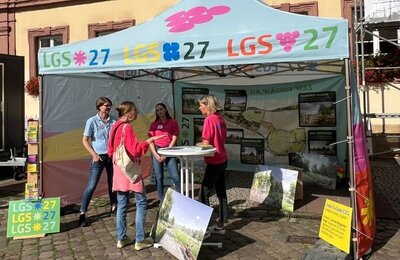 Bild vergr&ouml;&szlig;ern: Mitarbeiterinnen und eine Besucherin am Stand der LGS27 beim Zukunftstags in Neustadt an der Weinstraße