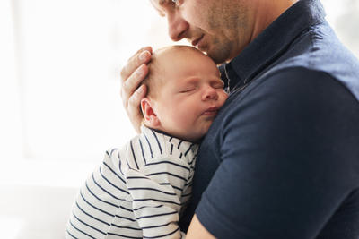 Bild vergrößern: Young father holding her newborn baby