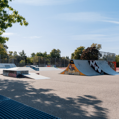 Bild vergr&ouml;&szlig;ern: Abenteuerspielplatz Böbig mit Blick auf Rampen mit Graffiti. Im Hintergrund ein Fupballplatz.