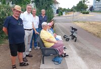 Bild vergr&ouml;&szlig;ern: Probesitzen auf der neuen Bank (v.li.): Ernst Ohmer, Baudezernent Adams, Markleiter Wessalowski sowie weitere Seniorinnen und Senioren aus Branchweiler.
