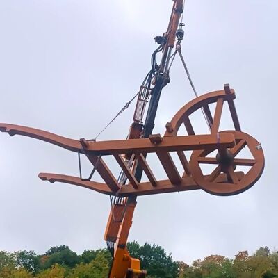 Bild vergr&ouml;&szlig;ern: Die Haardter Rieseschubkarre hängt an einem Kran in der Luft.