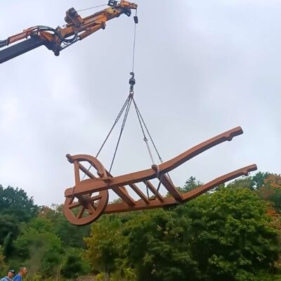 Bild vergr&ouml;&szlig;ern: Die Haardter Rieseschubkarre hängt an einem Kran in der Luft.