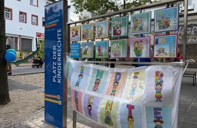 Bild vergr&ouml;&szlig;ern: Auf dem Platz der Kinderrechte stehen eine Stele und Tafeln mit Illustrationen, die auf den Platz hinweisen.