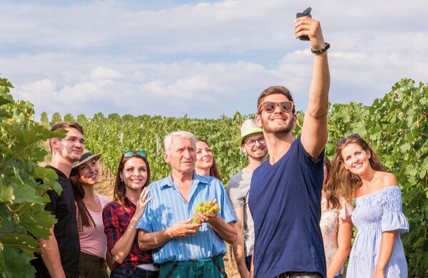 Ein Mann macht ein Foto von einer Gruppe im Weinberg  – Gästeführungen für Gruppen